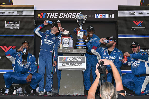 Kyle Larson, driver of the HendrickCars.com Chevrolet, and crew celebrate in victory lane after winning the NASCAR Cup Series Enjoy Illinois 300 at...