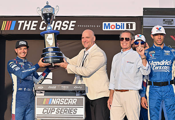 Kyle Larson, driver of the HendrickCars.com Chevrolet, is presented the Illinois 300 trophy in victory lane after winning the NASCAR Cup Series Enjoy...